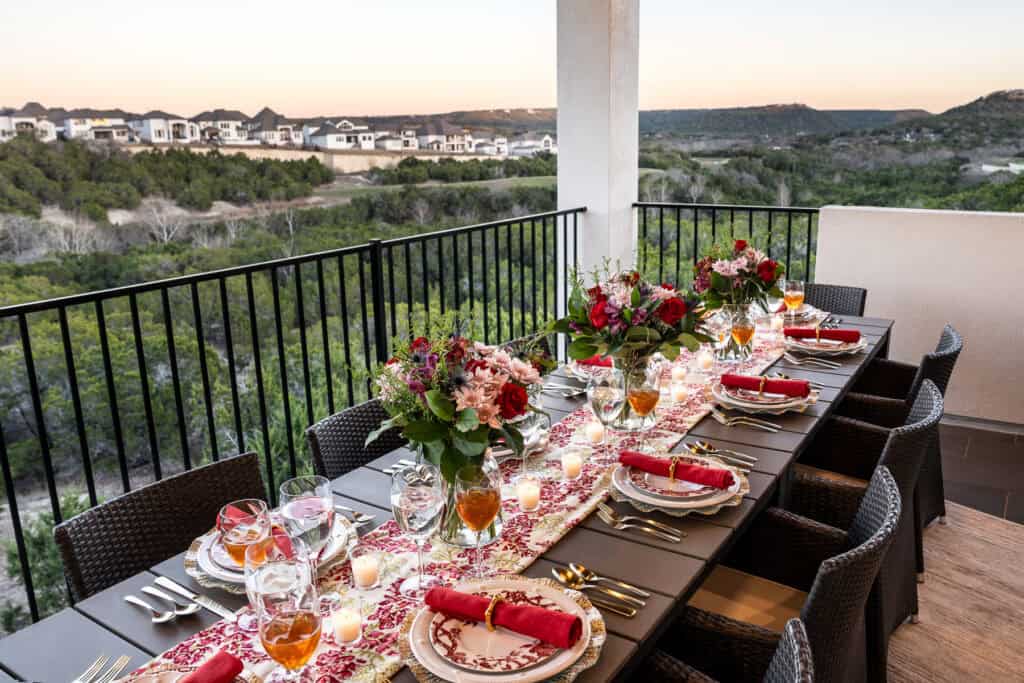 Outdoor holiday dining table with floral centerpieces and festive tableware.