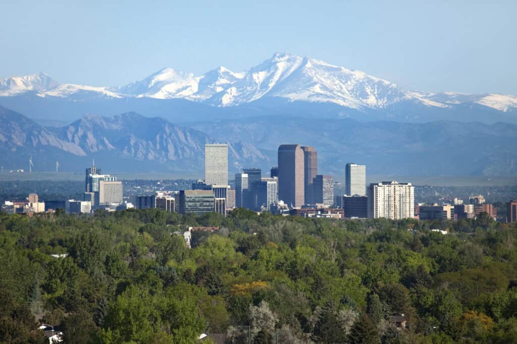 Austin skyline with downtown buildings and snow-covered mountains in the background.