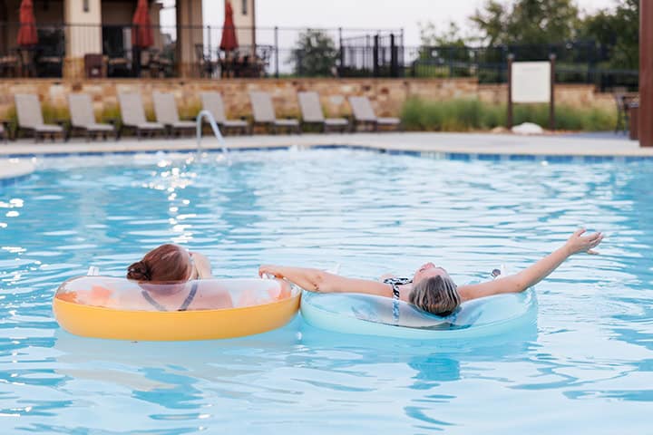 Two people floating in the pool at the Palazzo Clubhouse