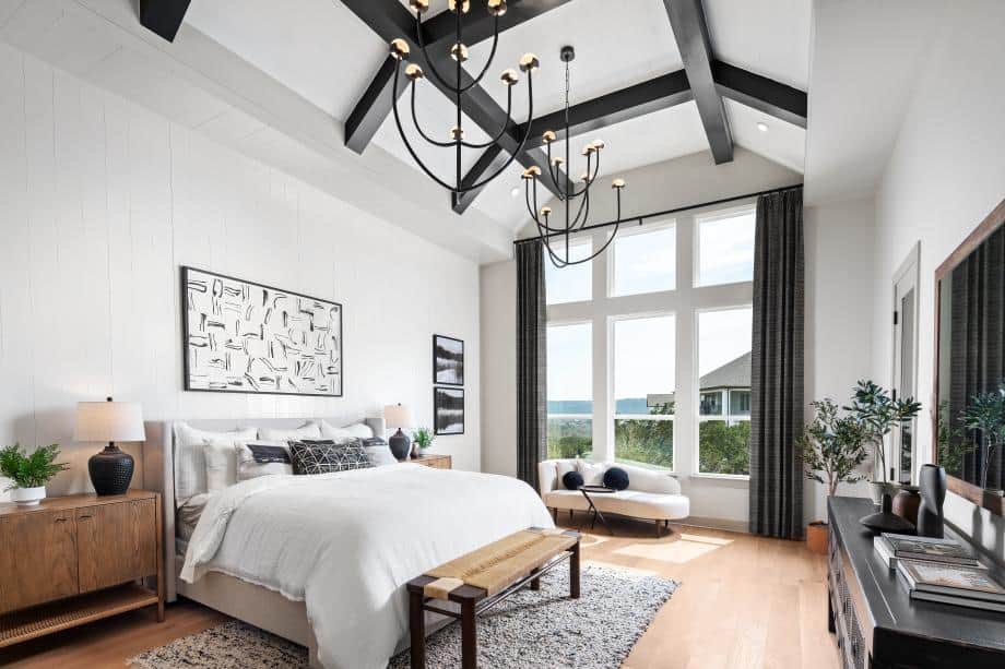 Spacious bedroom featuring large windows, vaulted ceiling, and contemporary decor.