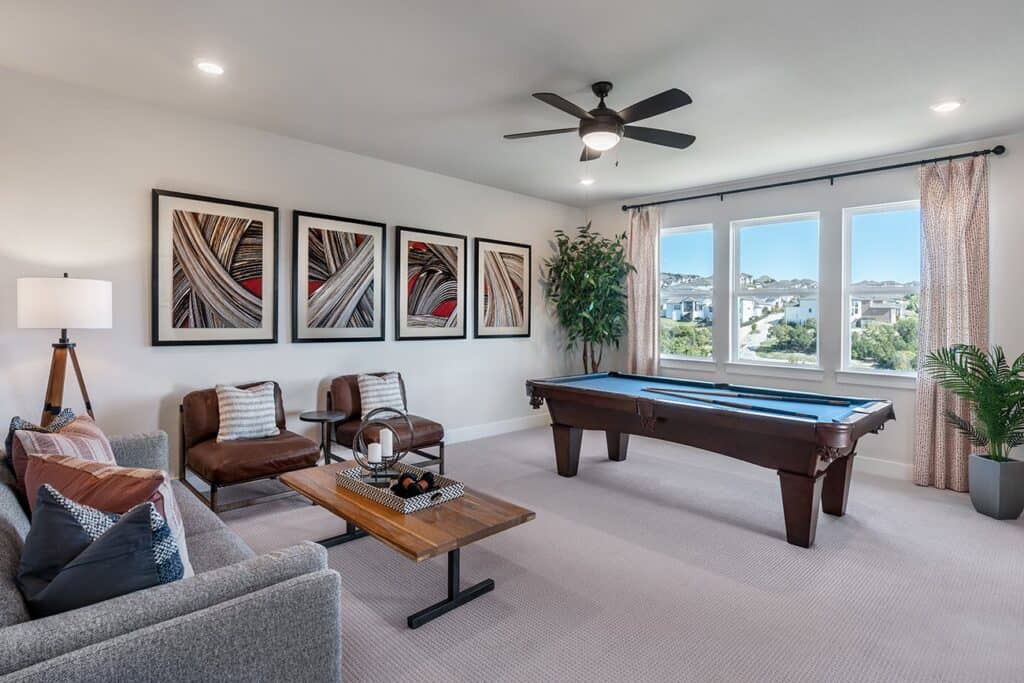 Spacious living room featuring a pool table, stylish decor, and large windows with scenic views.