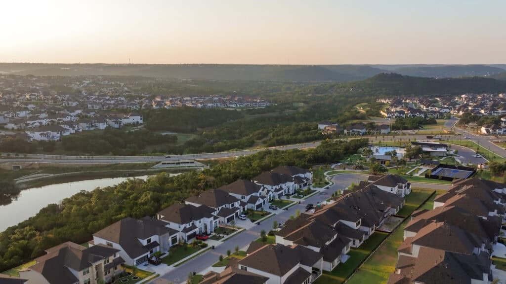 Aerial view of Leander, TX neighborhoods with scenic landscape and modern homes.