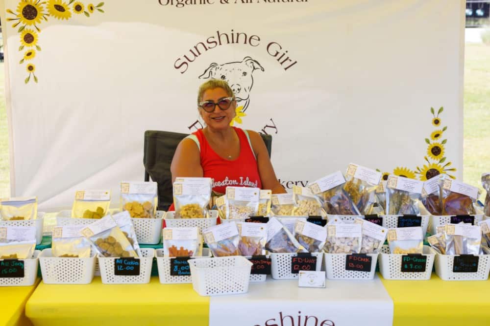 Woman selling organic snacks at Travisso community event.